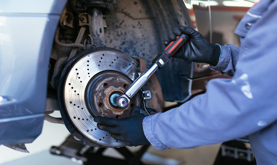 Mechanic holding a tool for fixing car's brake.